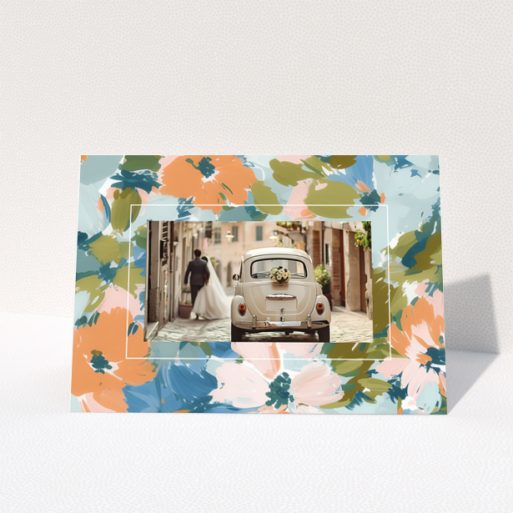 Wedding invitation design with floral border and a photo of a couple by a vintage car.