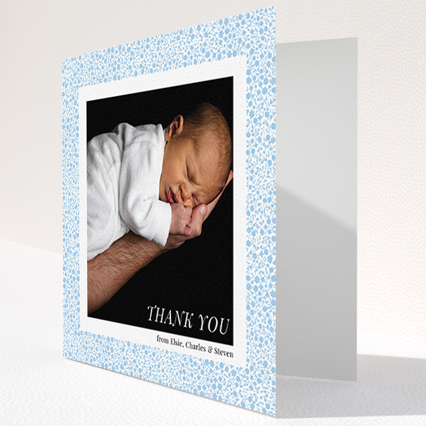 A baby card named "Blue Floral Frame". It is a square (148mm x 148mm) card in a square orientation. It is a photographic baby card with room for 1 photo. "Blue Floral Frame" is available as a folded card, with tones of blue and white.