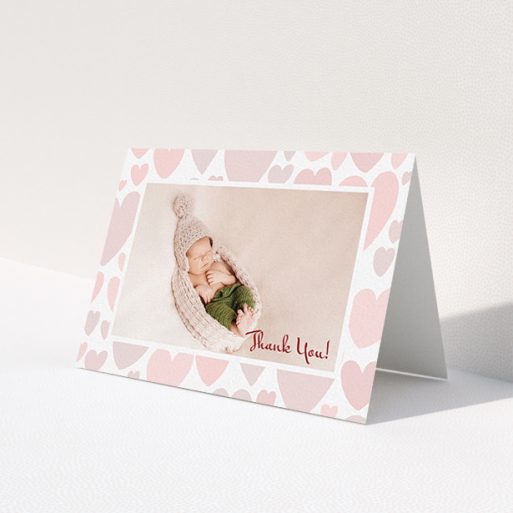 A baby card template titled 'Pastel Hearts'. It is an A6 card in a landscape orientation. It is a photographic baby card with room for 1 photo. 'Pastel Hearts' is available as a folded card, with tones of pink and white.