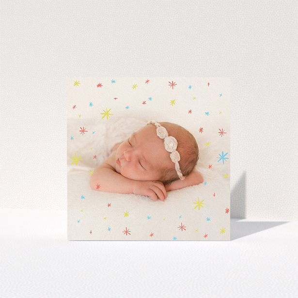 A baby card design named "Playground Sparkles". It is a square (148mm x 148mm) card in a square orientation. It is a photographic baby card with room for 1 photo. "Playground Sparkles" is available as a folded card, with mainly red colouring.