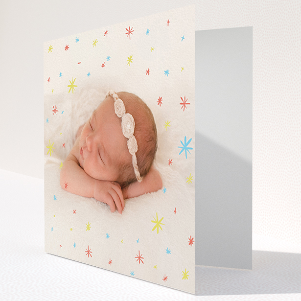 A baby card design named "Playground Sparkles". It is a square (148mm x 148mm) card in a square orientation. It is a photographic baby card with room for 1 photo. "Playground Sparkles" is available as a folded card, with mainly red colouring.