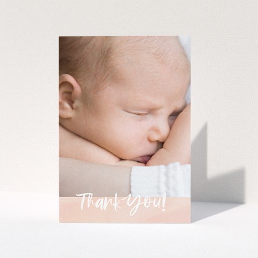 A baby card design called "Watercolour Thanks". It is an A6 card in a portrait orientation. It is a photographic baby card with room for 1 photo. "Watercolour Thanks" is available as a folded card, with tones of pink and white.