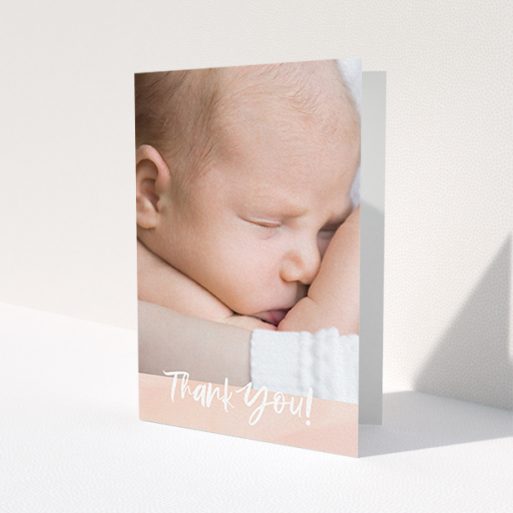 A baby card design called 'Watercolour Thanks'. It is an A6 card in a portrait orientation. It is a photographic baby card with room for 1 photo. 'Watercolour Thanks' is available as a folded card, with tones of pink and white.