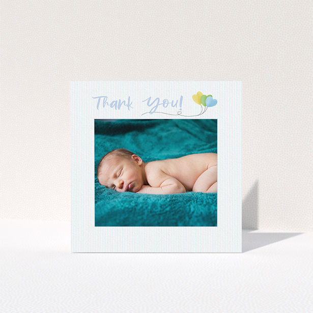 A baby thank you card design named "Balloooons". It is a square (148mm x 148mm) card in a square orientation. It is a photographic baby thank you card with room for 1 photo. "Balloooons" is available as a folded card, with mainly blue colouring.