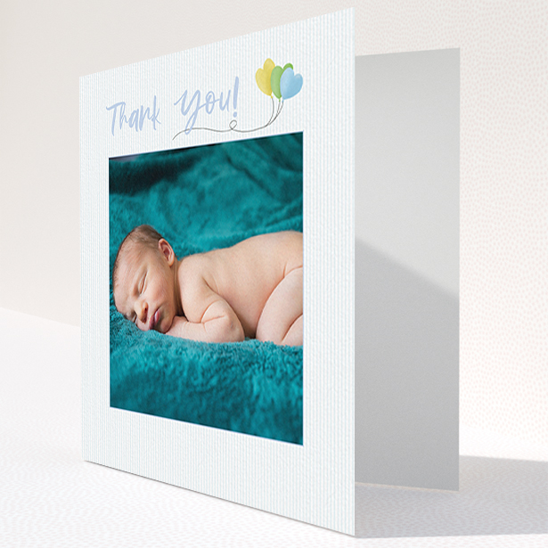 A baby thank you card design named "Balloooons". It is a square (148mm x 148mm) card in a square orientation. It is a photographic baby thank you card with room for 1 photo. "Balloooons" is available as a folded card, with mainly blue colouring.