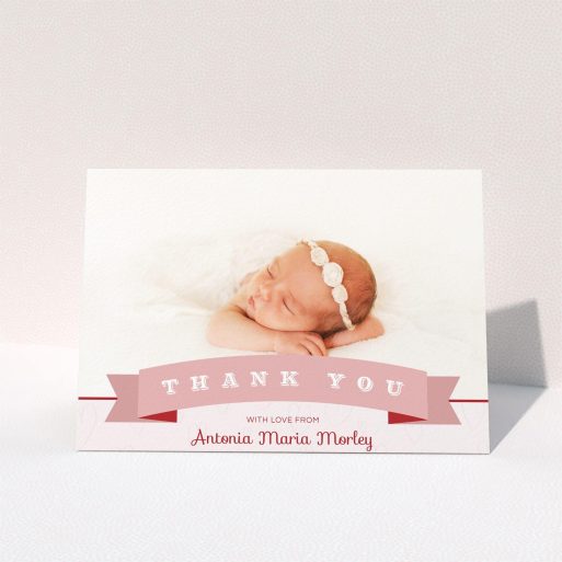 A baby thank you card called "Big Banner". It is an A5 card in a landscape orientation. It is a photographic baby thank you card with room for 1 photo. "Big Banner" is available as a folded card, with tones of pink and white.