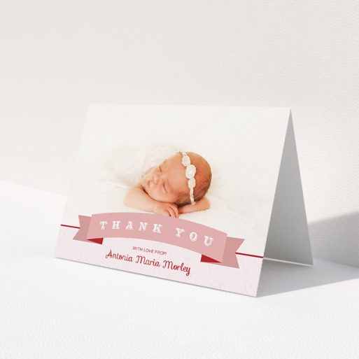 A baby thank you card called 'Big Banner'. It is an A5 card in a landscape orientation. It is a photographic baby thank you card with room for 1 photo. 'Big Banner' is available as a folded card, with tones of pink and white.