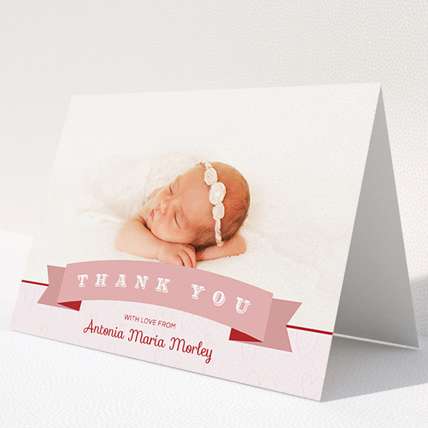 A baby thank you card called "Big Banner". It is an A5 card in a landscape orientation. It is a photographic baby thank you card with room for 1 photo. "Big Banner" is available as a folded card, with tones of pink and white.
