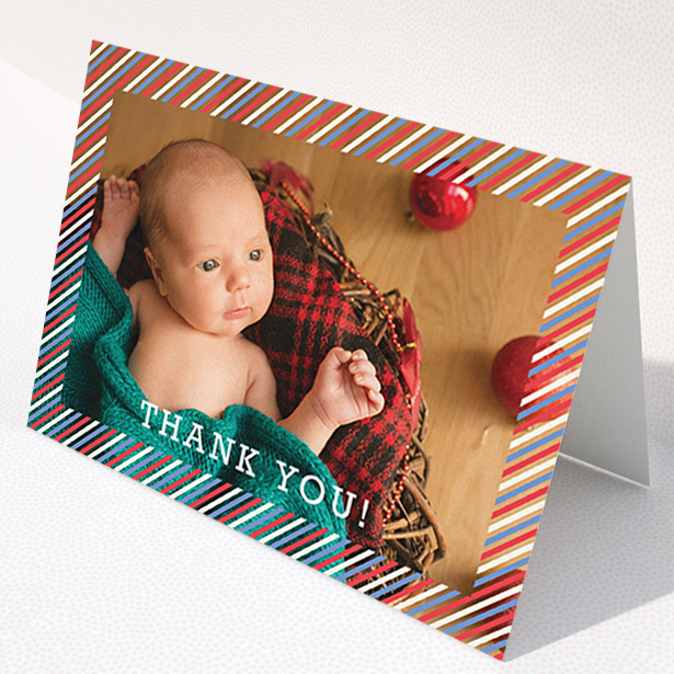 A baby thank you card called "Blue, Red and White Slant". It is an A6 card in a landscape orientation. It is a photographic baby thank you card with room for 1 photo. "Blue, Red and White Slant" is available as a folded card, with mainly red colouring.