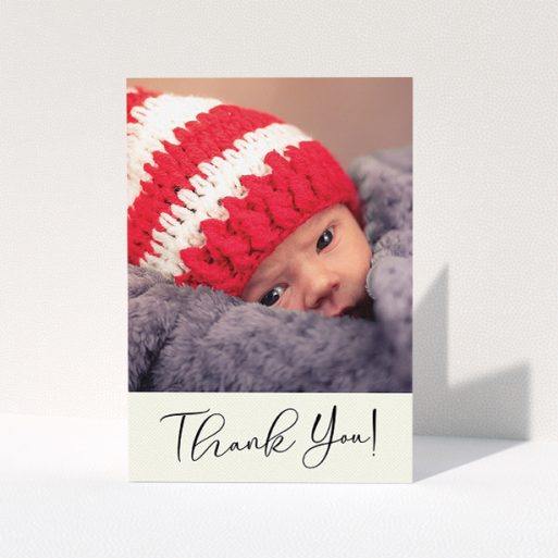 A baby thank you card named "Cursive Thanks". It is an A5 card in a portrait orientation. It is a photographic baby thank you card with room for 1 photo. "Cursive Thanks" is available as a folded card, with mainly cream colouring.