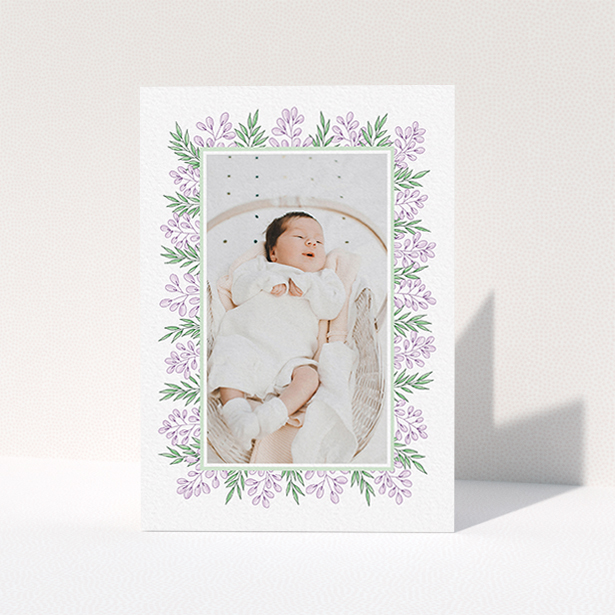 A baby thank you card named "Floral Frame". It is an A6 card in a portrait orientation. It is a photographic baby thank you card with room for 1 photo. "Floral Frame" is available as a folded card, with tones of purple and green.