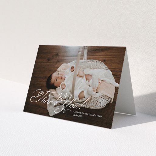 A baby thank you card called 'Flourished Thank You'. It is an A5 card in a landscape orientation. It is a photographic baby thank you card with room for 1 photo. 'Flourished Thank You' is available as a folded card, with mainly white colouring.