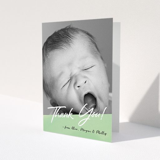 A baby thank you card design titled 'Green Slant'. It is an A6 card in a portrait orientation. It is a photographic baby thank you card with room for 1 photo. 'Green Slant' is available as a folded card, with mainly green colouring.