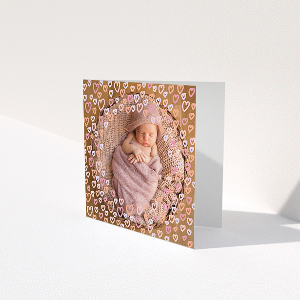 A baby thank you card design titled "Heart Overlay". It is a square (148mm x 148mm) card in a square orientation. It is a photographic baby thank you card with room for 1 photo. "Heart Overlay" is available as a folded card, with mainly pink colouring.