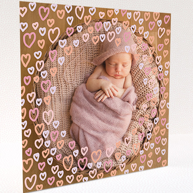 A baby thank you card design titled "Heart Overlay". It is a square (148mm x 148mm) card in a square orientation. It is a photographic baby thank you card with room for 1 photo. "Heart Overlay" is available as a folded card, with mainly pink colouring.