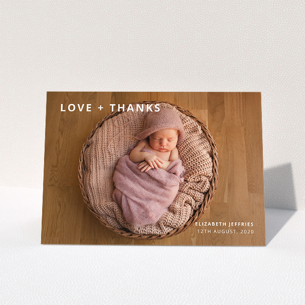 A baby thank you card named "Love and Thanks Landscape". It is an A5 card in a landscape orientation. It is a photographic baby thank you card with room for 1 photo. "Love and Thanks Landscape" is available as a folded card, with mainly white colouring.