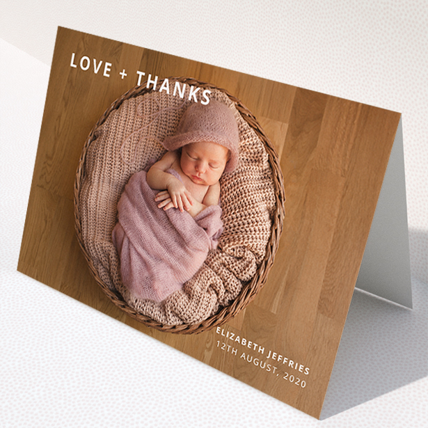 A baby thank you card named "Love and Thanks Landscape". It is an A5 card in a landscape orientation. It is a photographic baby thank you card with room for 1 photo. "Love and Thanks Landscape" is available as a folded card, with mainly white colouring.