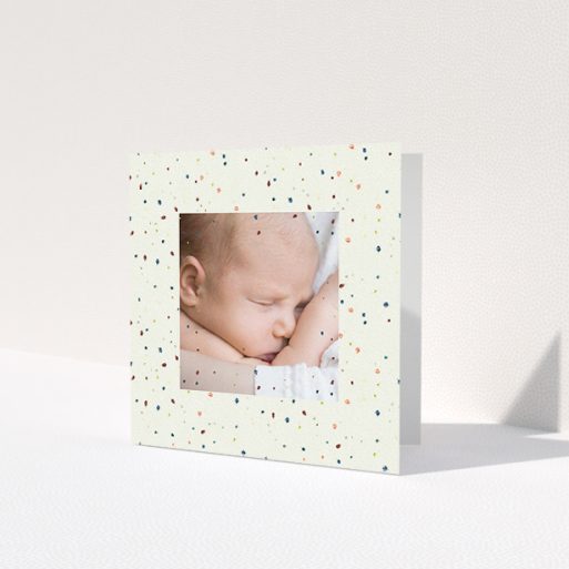 A baby thank you card design called 'Pastel Dots'. It is a square (148mm x 148mm) card in a square orientation. It is a photographic baby thank you card with room for 1 photo. 'Pastel Dots' is available as a folded card, with tones of light cream and green.