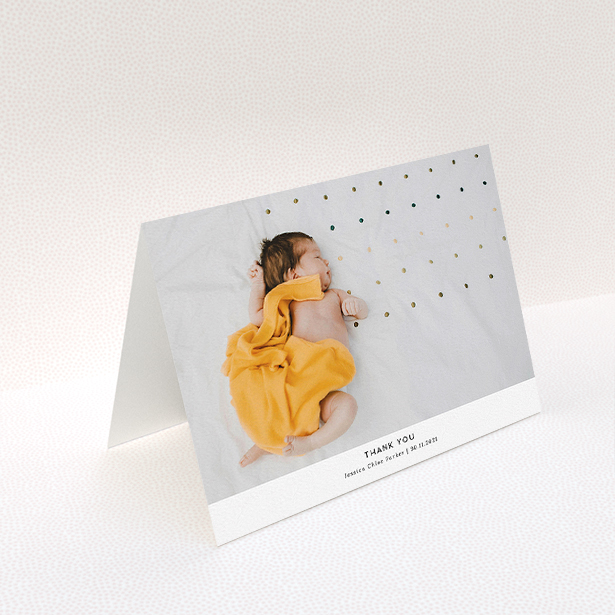 A baby thank you card design named "Sans Serif". It is an A5 card in a landscape orientation. It is a photographic baby thank you card with room for 1 photo. "Sans Serif" is available as a folded card, with mainly white colouring.