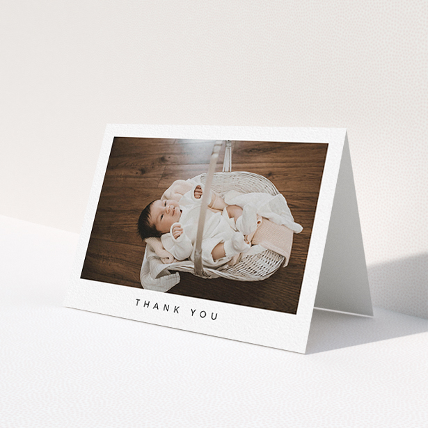 A baby thank you card design named "Simple". It is an A6 card in a landscape orientation. It is a photographic baby thank you card with room for 1 photo. "Simple" is available as a folded card, with mainly white colouring.