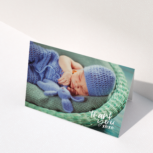 A baby thank you card design called "Thanks In the Corner". It is an A5 card in a landscape orientation. It is a photographic baby thank you card with room for 1 photo. "Thanks In the Corner" is available as a folded card, with mainly white colouring.