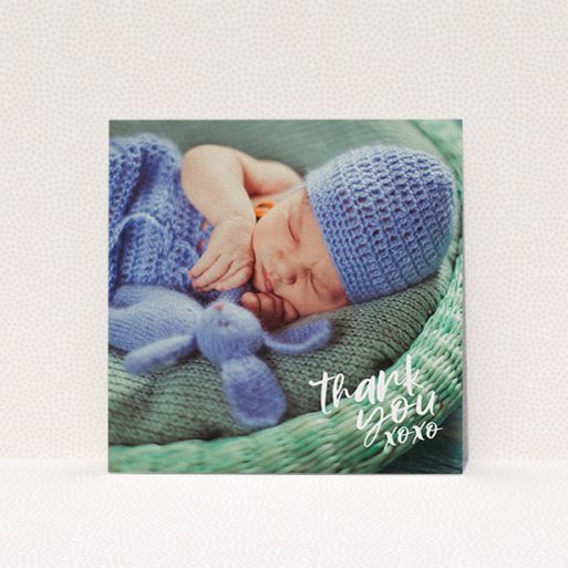 A baby thank you card design named "Thanks In the Corner". It is a square (148mm x 148mm) card in a square orientation. It is a photographic baby thank you card with room for 1 photo. "Thanks In the Corner" is available as a flat card, with mainly white colouring.