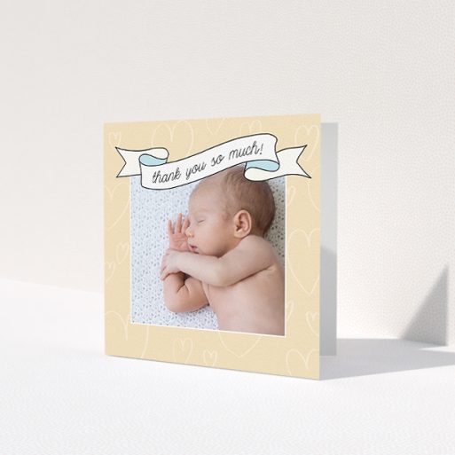 A baby thank you card called 'Written Above'. It is a square (148mm x 148mm) card in a square orientation. It is a photographic baby thank you card with room for 1 photo. 'Written Above' is available as a folded card, with tones of faded yellow and light blue.