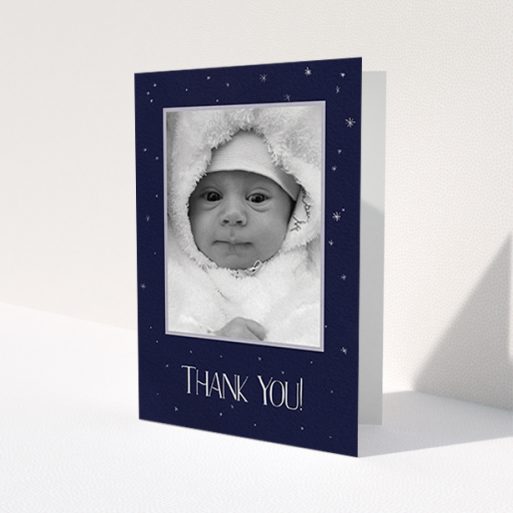 A baby thank you card design called 'Written in the Stars'. It is an A6 card in a portrait orientation. It is a photographic baby thank you card with room for 1 photo. 'Written in the Stars' is available as a folded card, with tones of navy blue and white.