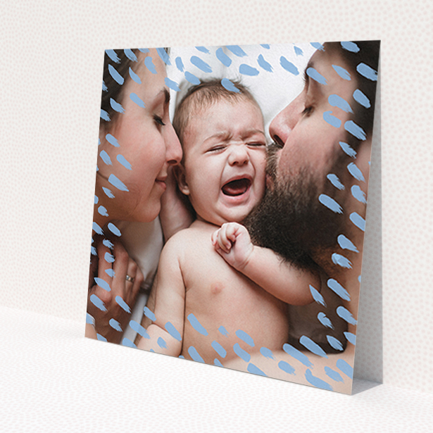 A baptism invitation design named 'Blue Dashes'. It is a square (148mm x 148mm) invite card in a square orientation. It is a photographic baptism invitation with room for 1 photo. 'Blue Dashes' is available as a flat invite card, with mainly blue colouring.