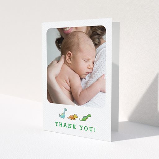 A baptism thank you card template titled 'BabySaurus'. It is an A6 card in a portrait orientation. It is a photographic baptism thank you card with room for 1 photo. 'BabySaurus' is available as a folded card, with tones of white, green and light blue.