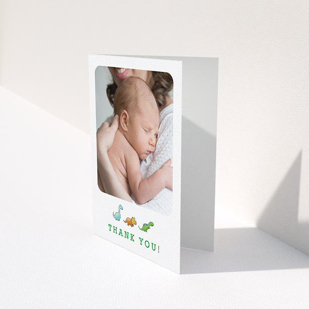 A baptism thank you card template titled "BabySaurus". It is an A6 card in a portrait orientation. It is a photographic baptism thank you card with room for 1 photo. "BabySaurus" is available as a folded card, with tones of white, green and light blue.