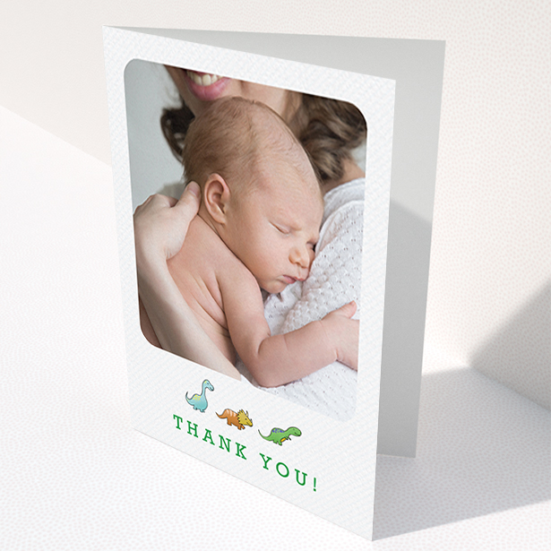A baptism thank you card template titled "BabySaurus". It is an A6 card in a portrait orientation. It is a photographic baptism thank you card with room for 1 photo. "BabySaurus" is available as a folded card, with tones of white, green and light blue.