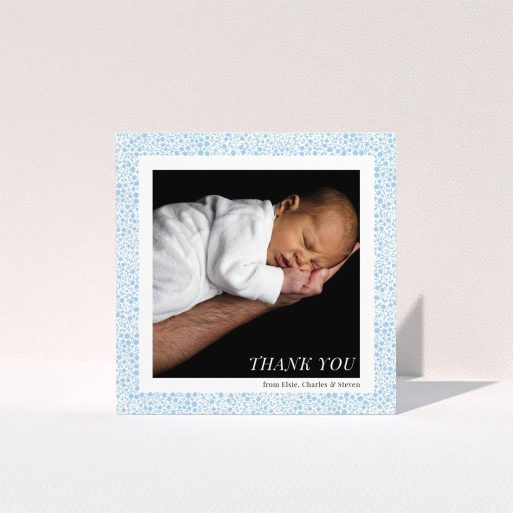 A baptism thank you card template titled "Blue Floral Frame". It is a square (148mm x 148mm) card in a square orientation. It is a photographic baptism thank you card with room for 1 photo. "Blue Floral Frame" is available as a folded card, with tones of blue and white.