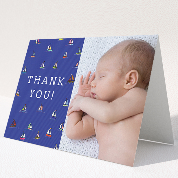 A baptism thank you card template titled "Cowes Week". It is an A5 card in a landscape orientation. It is a photographic baptism thank you card with room for 1 photo. "Cowes Week" is available as a folded card, with tones of blue, green and red.