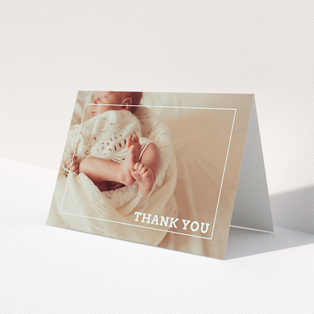 A baptism thank you card template titled 'Over Photo Frame'. It is an A6 card in a landscape orientation. It is a photographic baptism thank you card with room for 1 photo. 'Over Photo Frame' is available as a folded card, with mainly pale pink colouring.