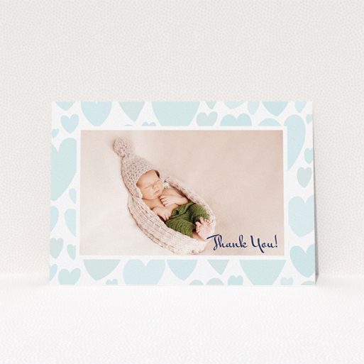 A baptism thank you card design called "Pastel Hearts". It is an A5 card in a landscape orientation. It is a photographic baptism thank you card with room for 1 photo. "Pastel Hearts" is available as a flat card, with tones of blue and white.
