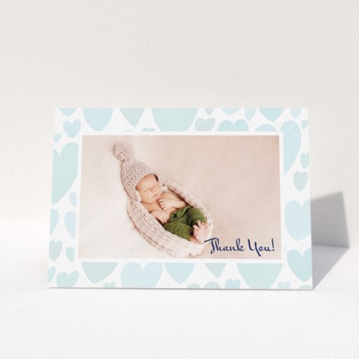 A baptism thank you card named "Pastel Hearts". It is an A6 card in a landscape orientation. It is a photographic baptism thank you card with room for 1 photo. "Pastel Hearts" is available as a folded card, with tones of blue and white.