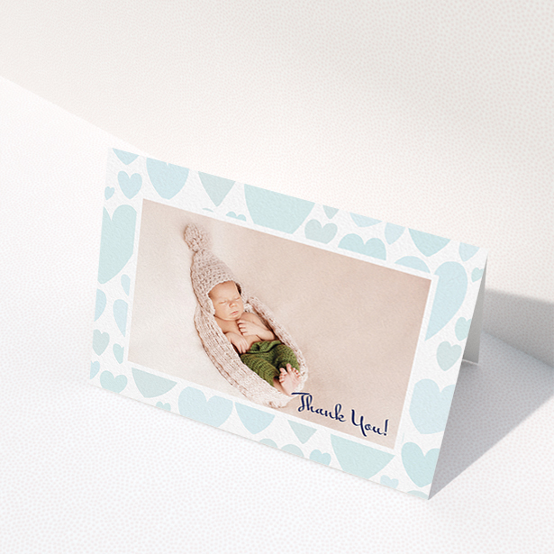 A baptism thank you card named "Pastel Hearts". It is an A6 card in a landscape orientation. It is a photographic baptism thank you card with room for 1 photo. "Pastel Hearts" is available as a folded card, with tones of blue and white.