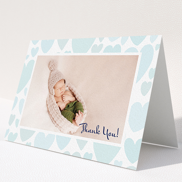 A baptism thank you card named "Pastel Hearts". It is an A6 card in a landscape orientation. It is a photographic baptism thank you card with room for 1 photo. "Pastel Hearts" is available as a folded card, with tones of blue and white.