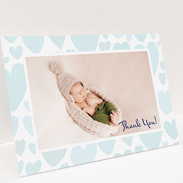 A baptism thank you card named "Pastel Hearts". It is an A6 card in a landscape orientation. It is a photographic baptism thank you card with room for 1 photo. "Pastel Hearts" is available as a folded card, with tones of blue and white.