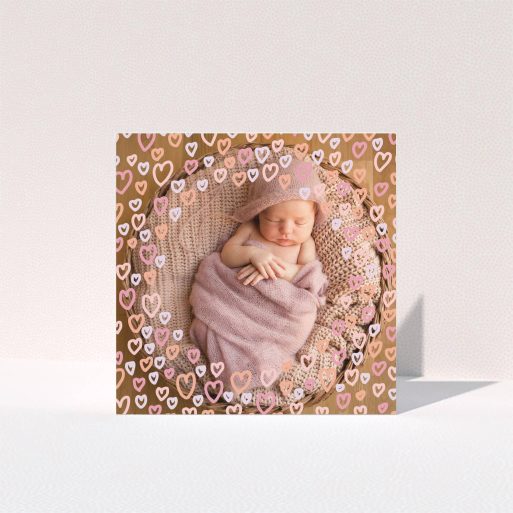 Baptism Thank You Card Design - "Pink Hearts" A baptism thank you card called "Pink Hearts". It is a square (148mm x 148mm) card in a square orientation. It is a photographic baptism thank you card with room for 1 photo. "Pink Hearts" is available as a folded card, with mainly pink colouring.