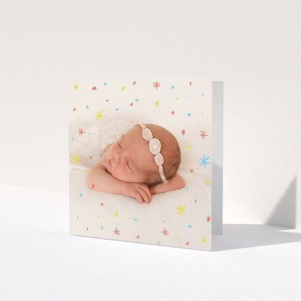 A baptism thank you card design titled 'Playground Sparkles'. It is a square (148mm x 148mm) card in a square orientation. It is a photographic baptism thank you card with room for 1 photo. 'Playground Sparkles' is available as a folded card, with mainly white colouring.