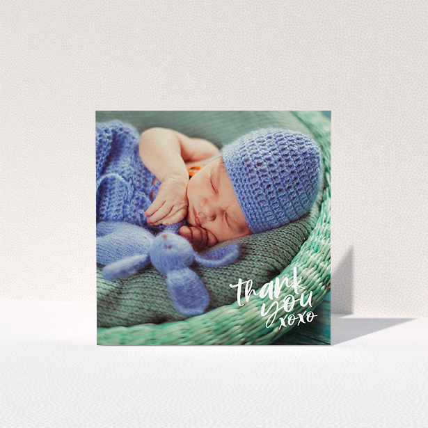 A baptism thank you card named "Thanks In the Corner". It is a square (148mm x 148mm) card in a square orientation. It is a photographic baptism thank you card with room for 1 photo. "Thanks In the Corner" is available as a folded card, with mainly white colouring.