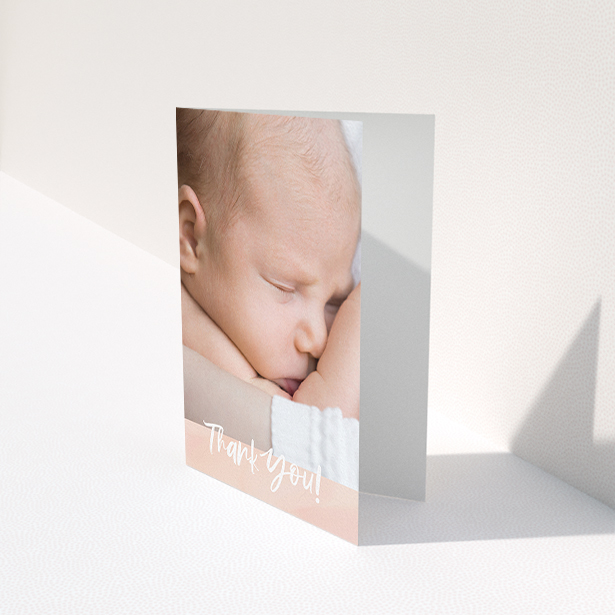 A baptism thank you card template titled "Watercolour Thanks". It is an A6 card in a portrait orientation. It is a photographic baptism thank you card with room for 1 photo. "Watercolour Thanks" is available as a folded card, with tones of pink and white.
