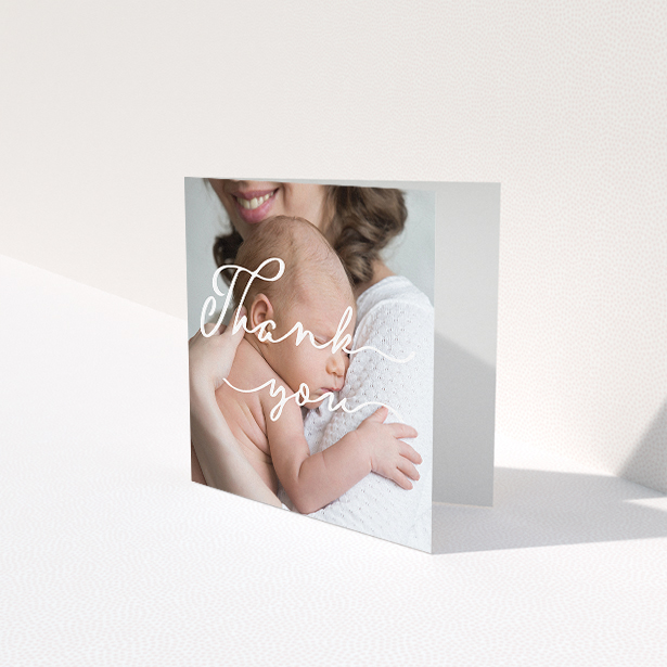 A baptism thank you card named "White Thank You". It is a square (148mm x 148mm) card in a square orientation. It is a photographic baptism thank you card with room for 1 photo. "White Thank You" is available as a folded card, with mainly white colouring.