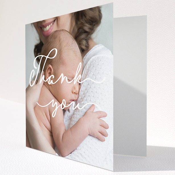 A baptism thank you card named "White Thank You". It is a square (148mm x 148mm) card in a square orientation. It is a photographic baptism thank you card with room for 1 photo. "White Thank You" is available as a folded card, with mainly white colouring.