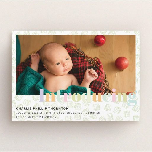 A birth announcement card called "Alphabet Blocks". It is an A5 card in a landscape orientation. It is a photographic birth announcement card with room for 1 photo. "Alphabet Blocks" is available as a flat card, with tones of green and purple.