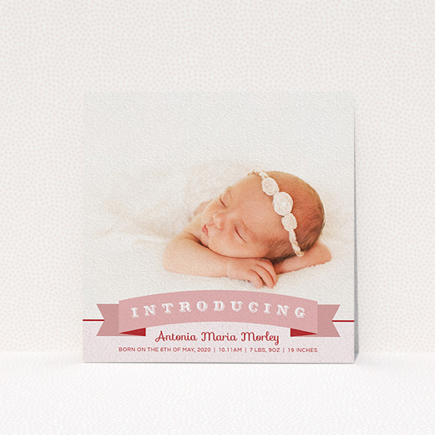 A birth announcement card design called "Big Banner". It is a square (148mm x 148mm) card in a square orientation. It is a photographic birth announcement card with room for 1 photo. "Big Banner" is available as a flat card, with tones of pink, red and white.