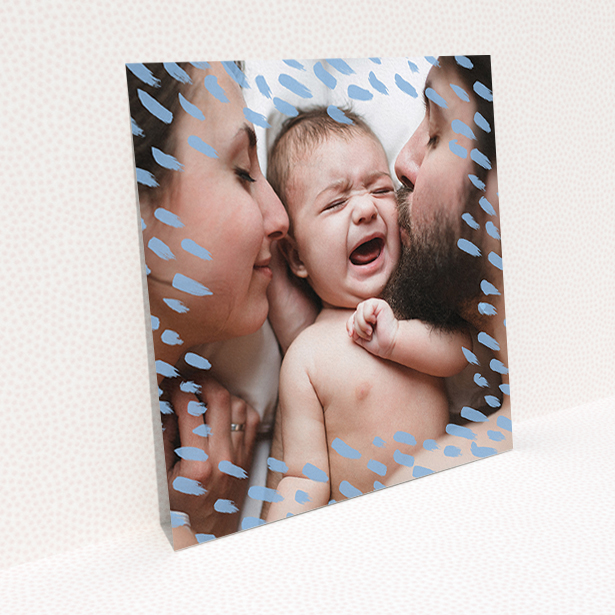 A birth announcement card called "Blue Dashes". It is a square (148mm x 148mm) card in a square orientation. It is a photographic birth announcement card with room for 1 photo. "Blue Dashes" is available as a flat card, with mainly blue colouring.