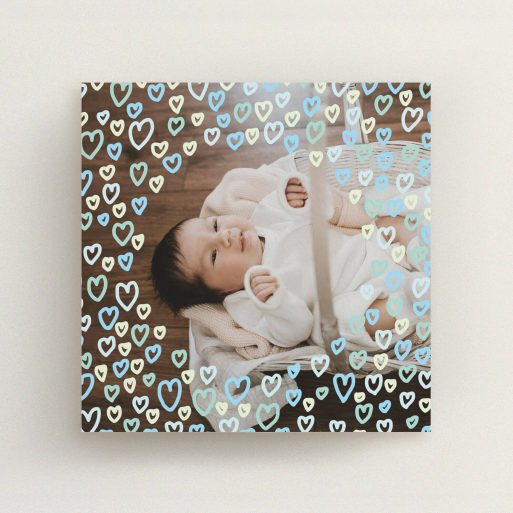 A birth announcement card design called "Blue Hearts". It is a square (148mm x 148mm) card in a square orientation. It is a photographic birth announcement card with room for 1 photo. "Blue Hearts" is available as a flat card, with mainly blue colouring.